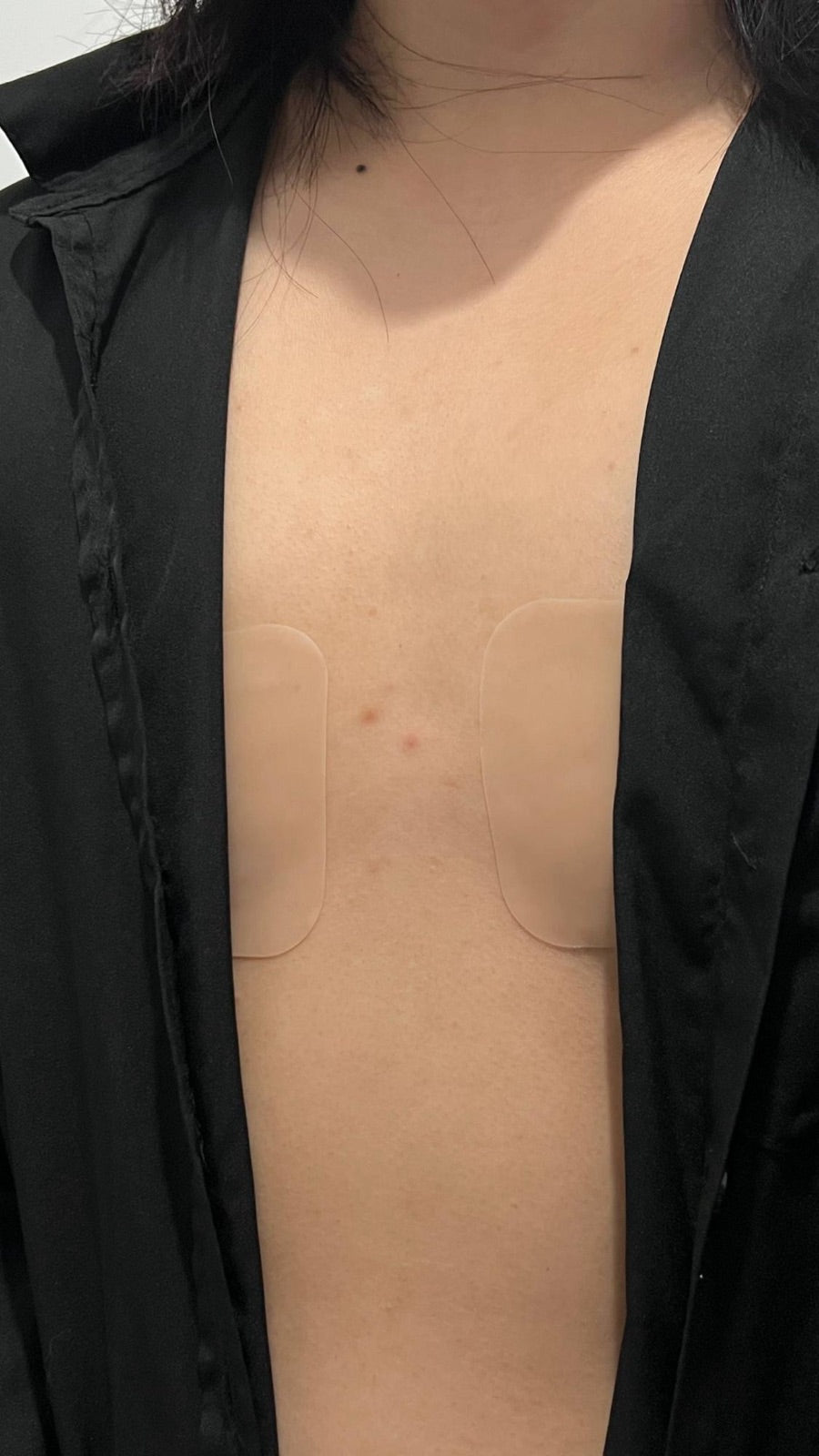 GlamorKit silicone boob tape worn under an open black shirt
