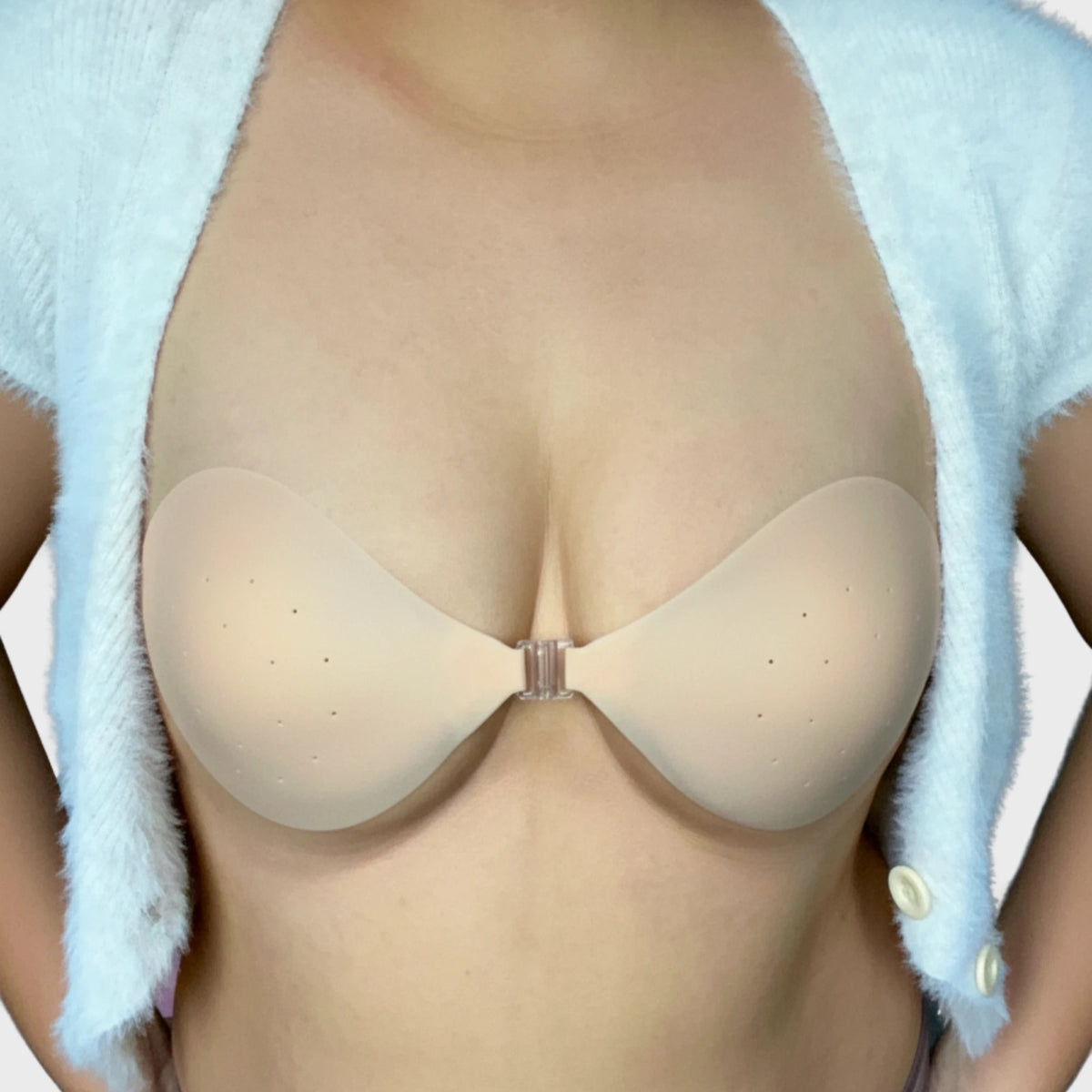 GlamorKit strapless silicone push-up bra with a front clasp, worn under an open cardigan